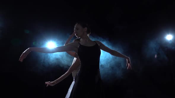 Romantic Ballerinas in White and Black Tutu Spinning in Dance. Close Up, Slow Motion.