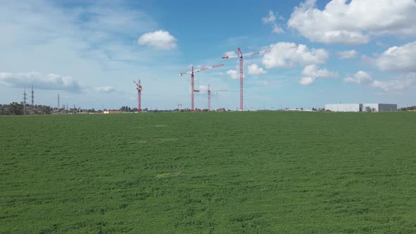 cranes at green fields in blu sky at southern district city sderot