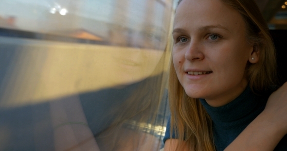 Woman In Train Using Cell And Looking Out The alt
