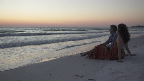 Couple Relaxing On Beach At Sunset (3 Of 5) alt