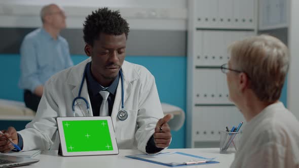 Medic of African Ethnicity Having Green Screen on Digital Tablet alt
