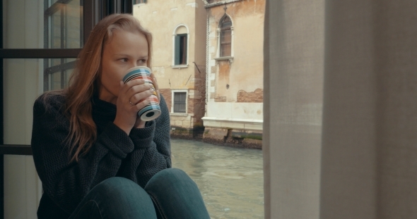 Wistful Woman Having Coffee At Home In Venice