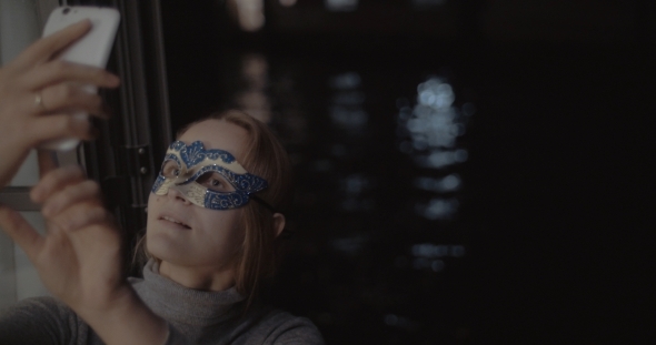 Woman In Carnival Mask Making Selfie With Phone