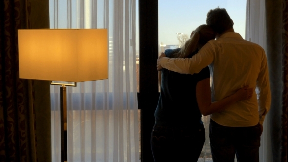 Young Couple Hugging And Looking Out The Window