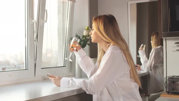 Young Blonde Woman Wearing Man's Shirt Drinking Champagne