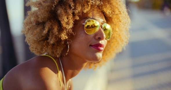 Smiling Girl With Afro Resting On Promenade