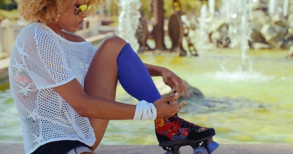Girl Tying Shoelaces In Her Roller Skates
