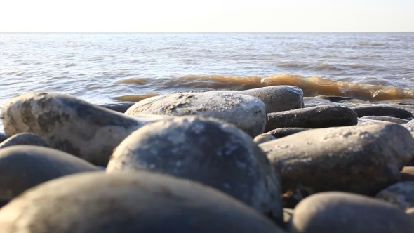 Dirty Water Into The Sea On The Pebble Beach With