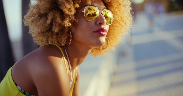 Sensual Girl With Afro Resting On Promenade
