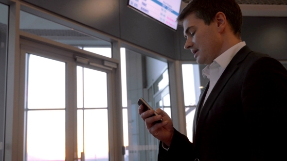 Businessman Chatting On The Phone At Airport