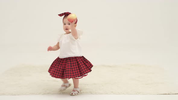 Little Girl in Plaid Headband is Holding Apple