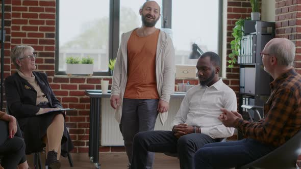 Cheerful Man Celebrating Addiction Progress with People Applauding at Aa Group Meeting