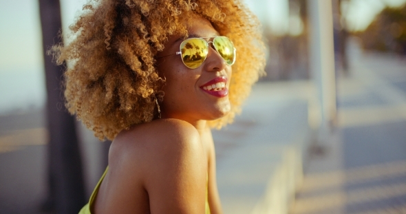 Smiling Girl With Afro Resting On Promenade