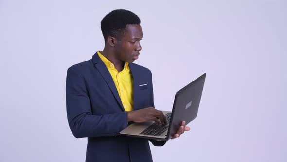 Young African Businessman Using Laptop and Looking Shocked