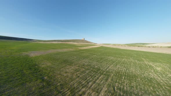 Open Green Grassy Field Near Mediterranean Countryside In Spain. HD FPV Aerial Drone.