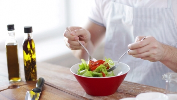 Close Of Male Hands Mixing Salad In Bowl