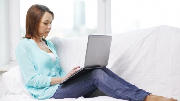 Smiling Woman With Laptop Computer At Home