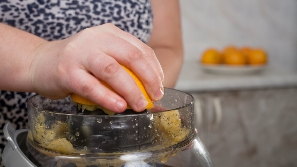 Close Up Of Female Hands Squeezing Orange