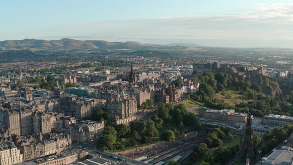 Long dolly back drone shot over central Edinburgh golden hour