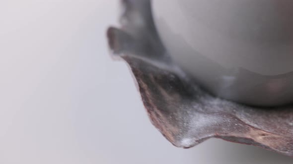 Dessert in the Form of Pearl with Gray Glaze Spinning on White Background