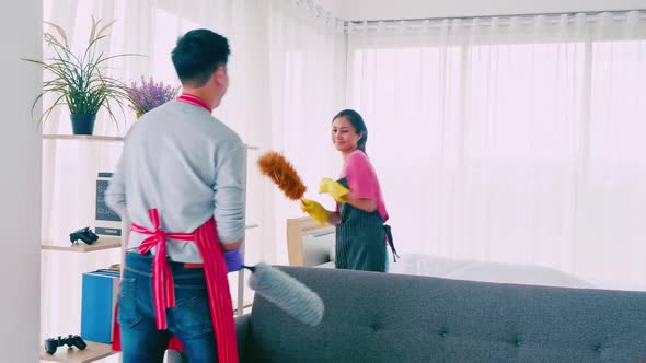 Husband and wife cleaning their room. Happy Asian couple spending time together at home.