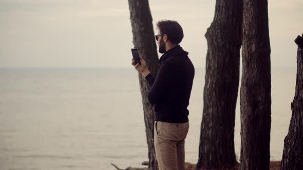 Man Taking Mobile Photo. Man Holding Mobile Phone And Taking Picture At Sunset.