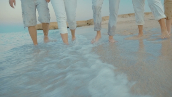 Four People Splashing Sea Water With Feet