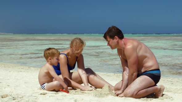 Young Family Building Sand Castle