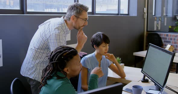 Business people discussing over computer in office 4k