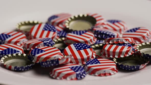 Rotating shot of bottle caps with the American flag printed on them - BOTTLE CAPS