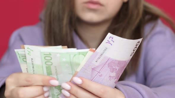 Close-up of a caucasian girl holding cash euro banknotes in her hands.Cash. Inflation is the devalua