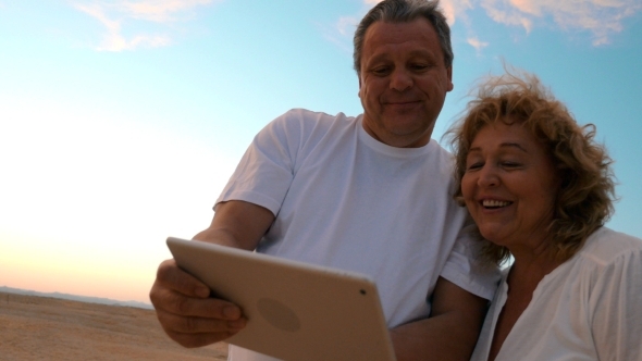 Senior Man And Woman With Tablet Computer Outdoors