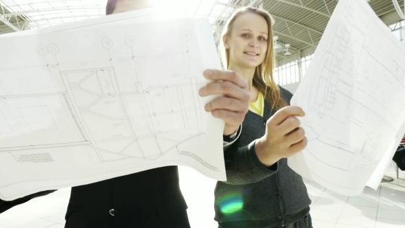 Man And Woman Looking At Construction Plans