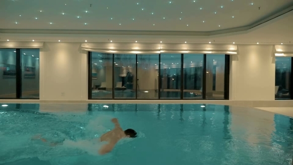 Man Swimming Alone In The Indoor Pool