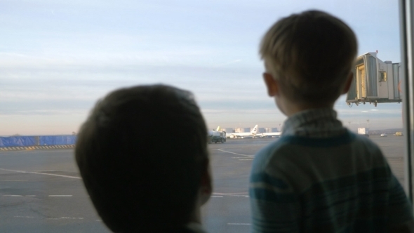 Father And Son Looking Out The Window At Airport