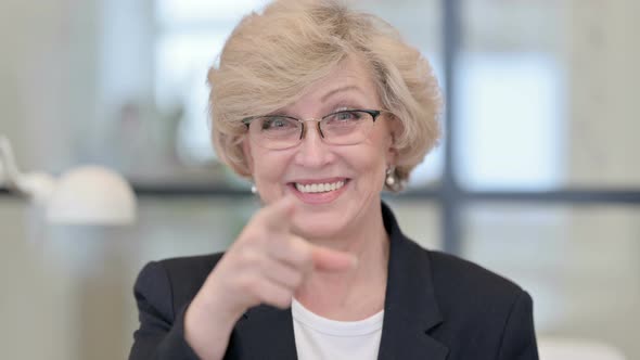 Portrait of Old Businesswoman Pointing and Inviting