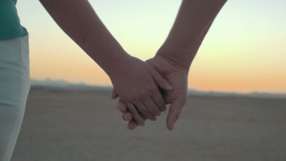 Loving Couple Holding Hands At Sunset