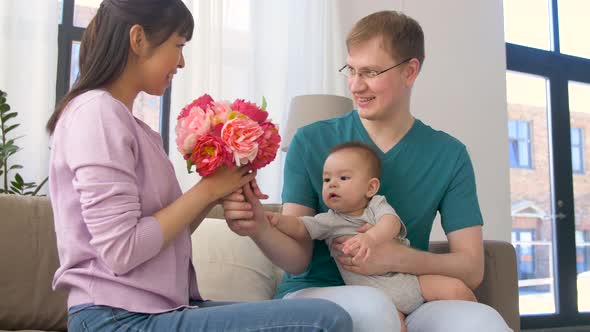 Happy Family with Flowers and Baby Boy at Home