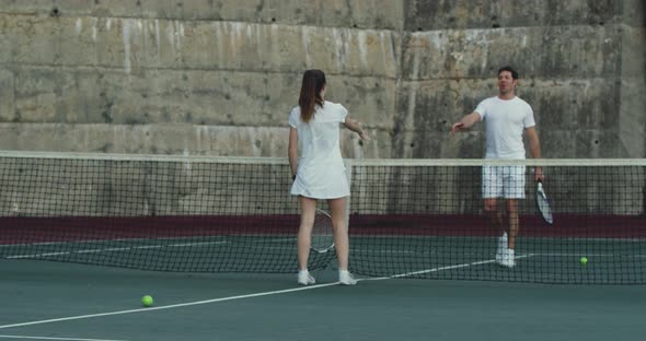 Woman and man playing tennis on a court