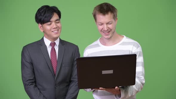 Young Handsome Asian Businessman and Young Scandinavian Businessman Working Together