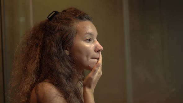 Mixed Race Young Woman with Curly Hair Applies Makeup Base