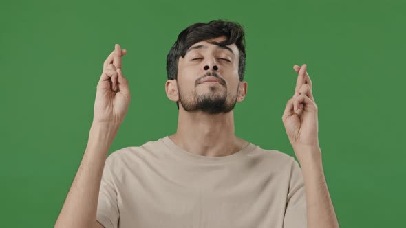 Portrait Arab Indian Hispanic Guy Hopeful Young Man Cross Fingers Praying for Fortune Luck