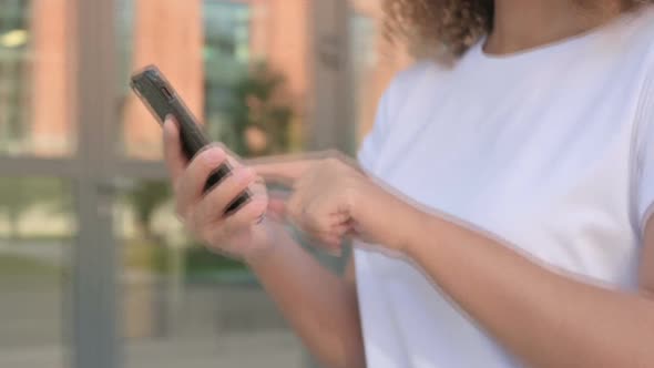 Walking African Woman Using Smartphone on Street