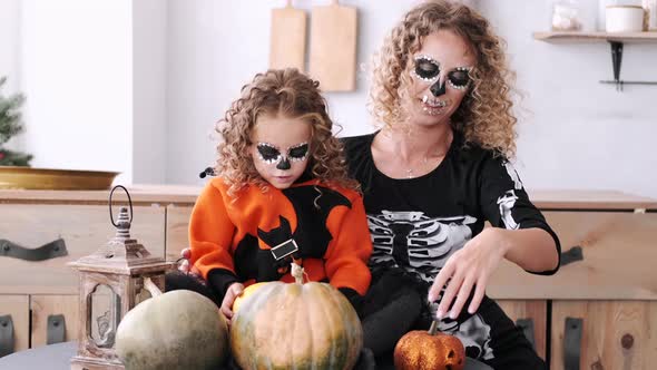 Mother and Daughter with Curly Hair Wearing Halloween Costumes