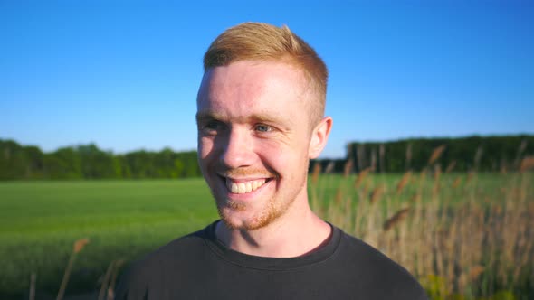 Portrait of Happy Man Standing and Looking Into Camera at Rural Environment. Handsome Guy with Beard