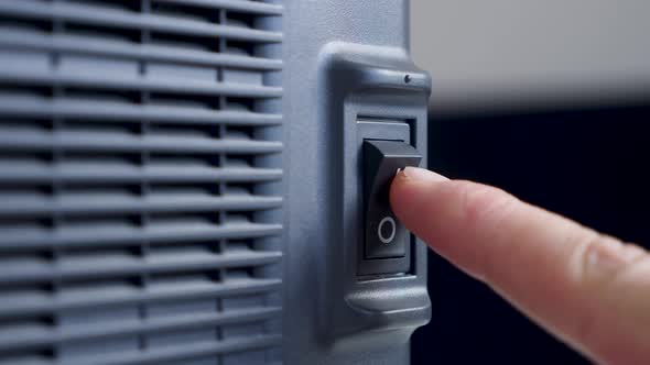 Finger of a Person Presses Turns on and Off on a Black Plastic Button