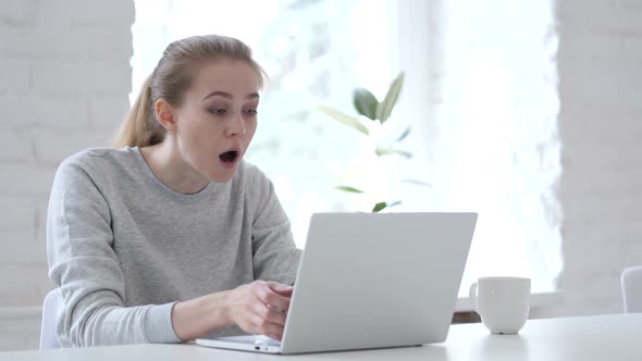 Young Woman in Shock Working on Laptop