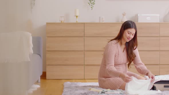 Asian pregnant woman preparing diaper,feeding bottle for baby at home