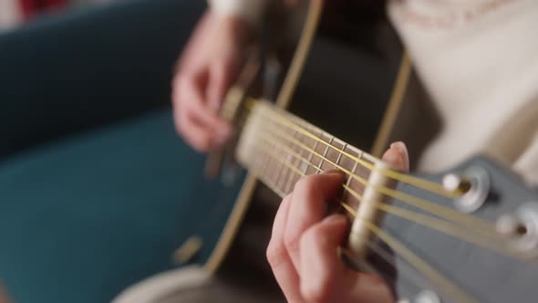 Young Man with Guitar Playing Songs in the Room at Home