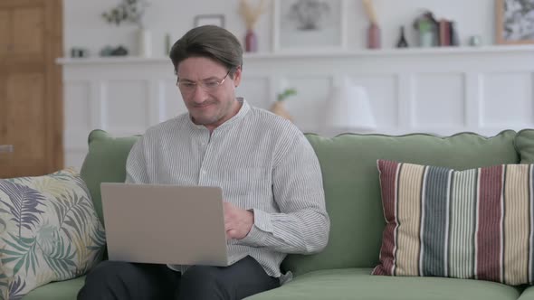 Man with Laptop Feeling Angry on Sofa
